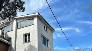 Ein zweistöckiges Gebäude mit flacher Fassade, zahlreichen Fenstern und einem sichtbaren Eingang.