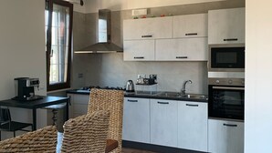 A modern kitchen with white cabinets, a built-in oven, and a coffee machine. - Cozy apartment 2 steps from Rome finely renovated and equipped (Marino)