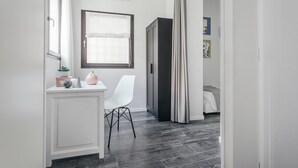 A modern bedroom with a bed, a bedside table, a chair, and a window with curtains. - Tristano e Isotta: Bright Three-room 6 Adults (Bologna)