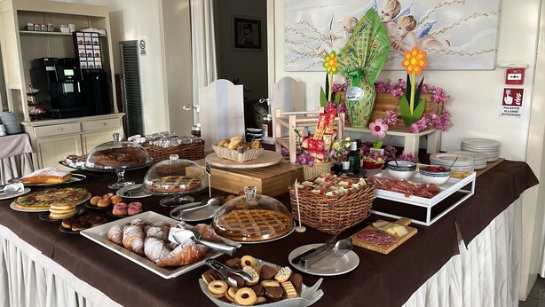 A buffet table with various food items, including pastries, meats, and condiments.