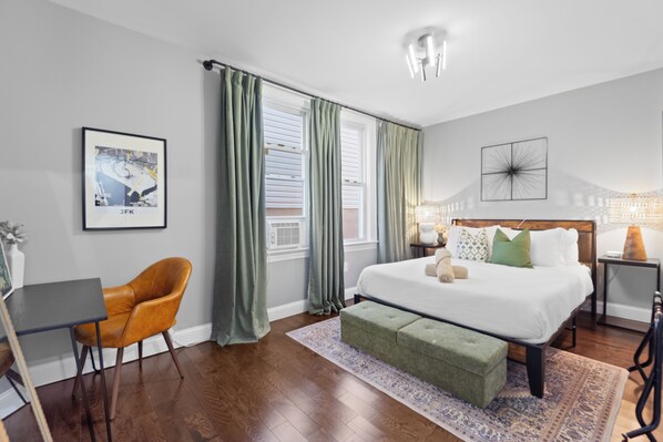 Un dormitorio moderno con una cama grande, un escritorio y una silla.