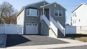 Une maison à deux étages avec un porche à l’avant, un escalier et un garage.
