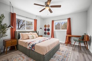 Relax in this serene bedroom with a large bed, bedside tables, and a ceiling fan above.