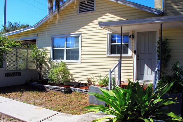 A single-story house with a front porch, a door, and windows.
