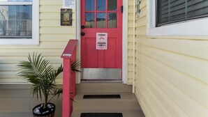 A red door with a sign indicating parking is only allowed to the left.