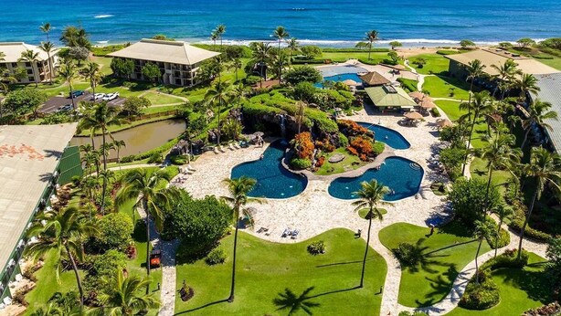 A resort with multiple swimming pools, palm trees, and a view of the ocean. - Top Floor Ocean View at 4-Star Kauai Resort. Pools & Slides (Lihue)