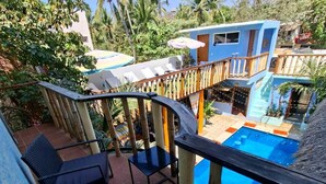 Un espace piscine doté de chaises longues et d’une terrasse en bois donnant sur la piscine.