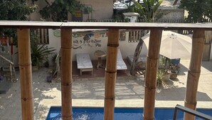 Un espace piscine avec des chaises longues et un panneau indiquant : « via Paradise by Pio ».
