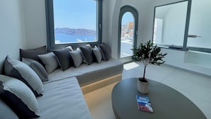 Ett modernt vardagsrum med en soffa, en krukväxt och en tidning på ett bord.