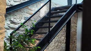 A staircase with a metal railing leading to an upper level. - NisUrla (Urla)