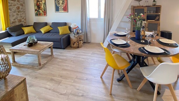 A modern living room with a sofa, coffee table, and dining area with chairs and a table set for four. - Old Antibes, 2 pcs sea view, air conditioning, beach 2min, restaurants, market (Antibes)