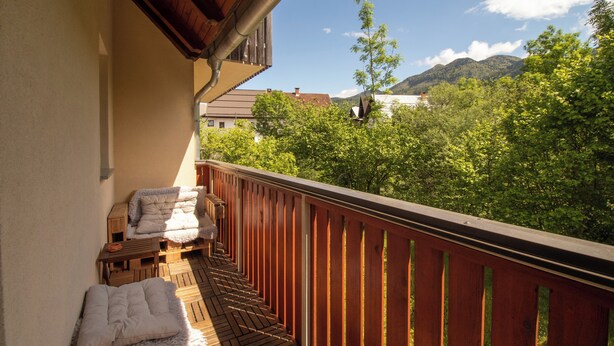 Ein Balkon mit Holzwertlauf, einer Couch und einem Tisch mit Handtüchern.