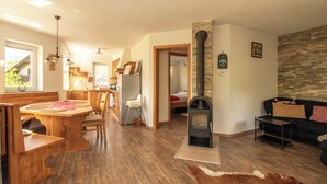 Ein großzügiger Wohnbereich mit einem Holzesstisch, einer Couch und einem Kamin.