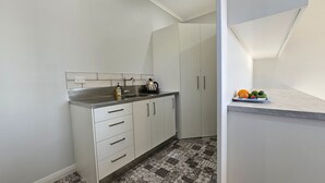 A compact kitchen with a sink, cabinets, and a tiled backsplash. - A large and sunny family home close to all the amenities and perfect for exploring Nelson and Tasman (Richmond)