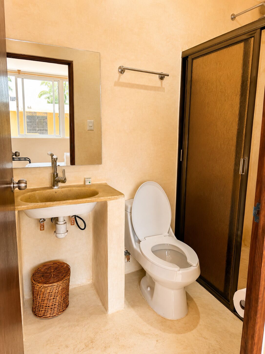 Une salle de bain avec des toilettes, un lavabo et un miroir.
