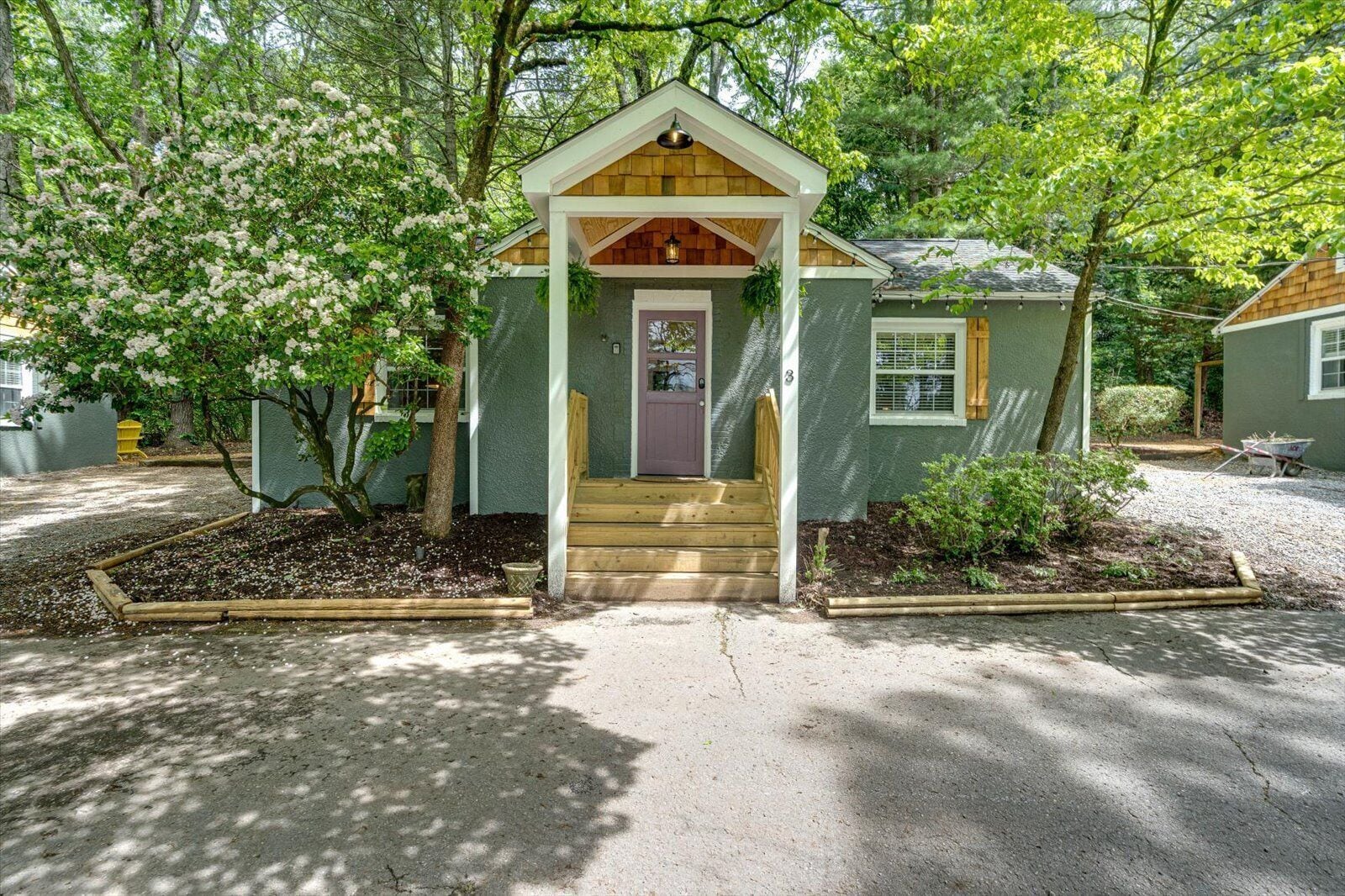 A small, single-story house with a front porch, a door, and a window.