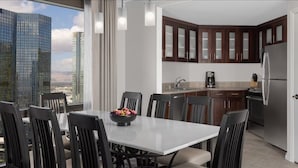 A modern kitchen with dark wooden cabinets and a stainless steel refrigerator.
