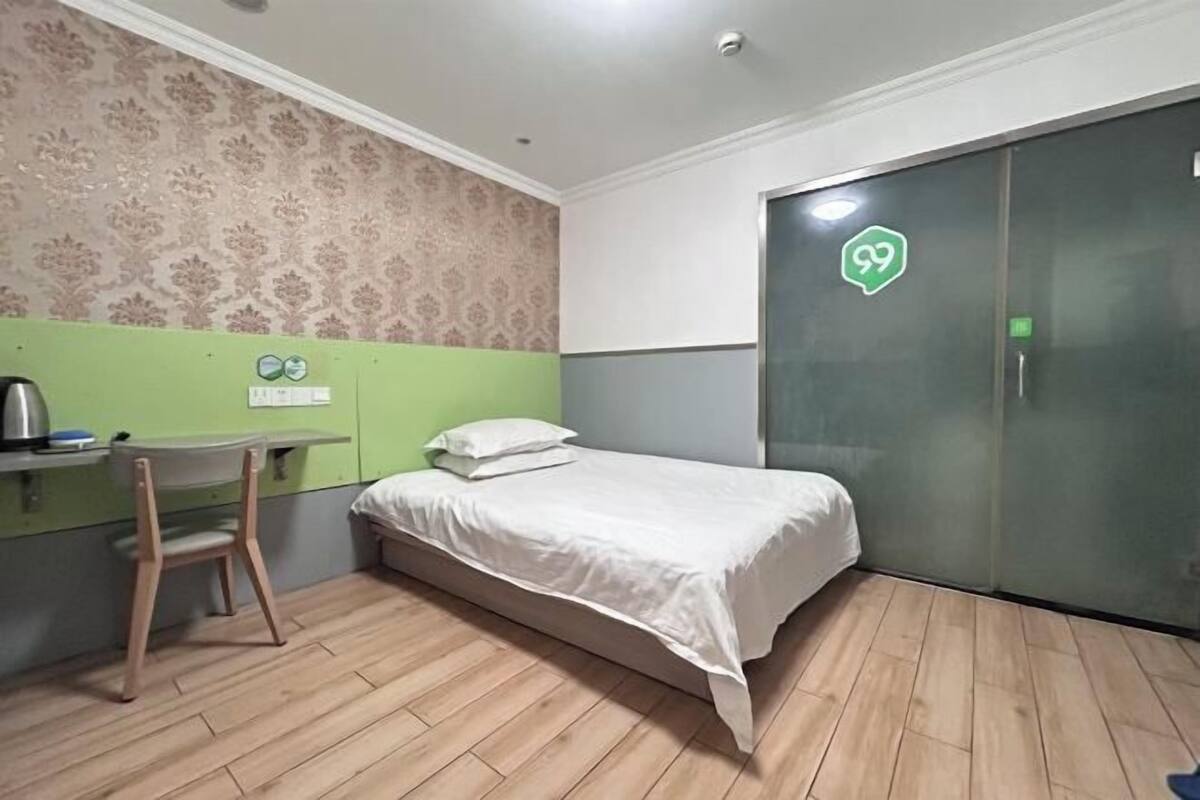 Una habitación con una cama, un escritorio y un armario.