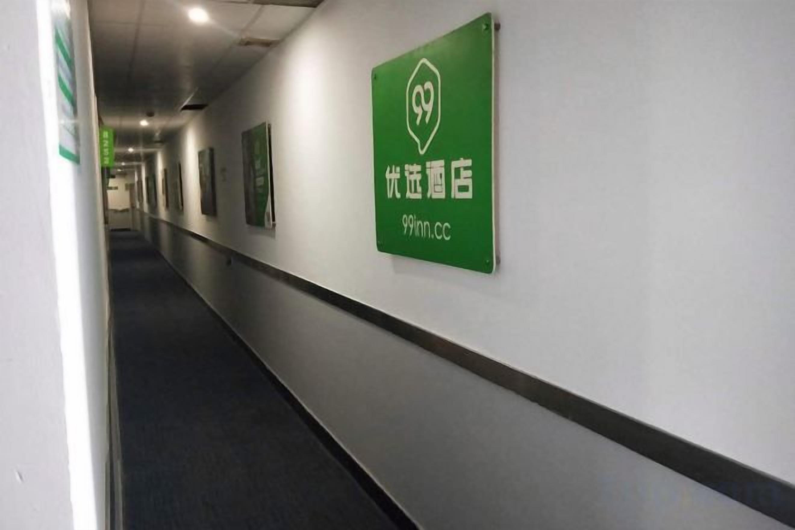A hallway with a green sign indicating a 99 Inn hotel.
