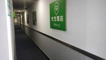 A hallway with a green sign indicating a 99 Inn hotel.