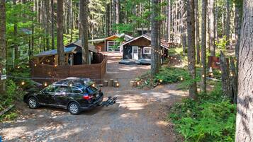 A forested area with a gravel path leading to a cabin-style building with a porch.