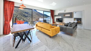 Un saló modern amb una finestra gran, una zona de menjador i un sofà.