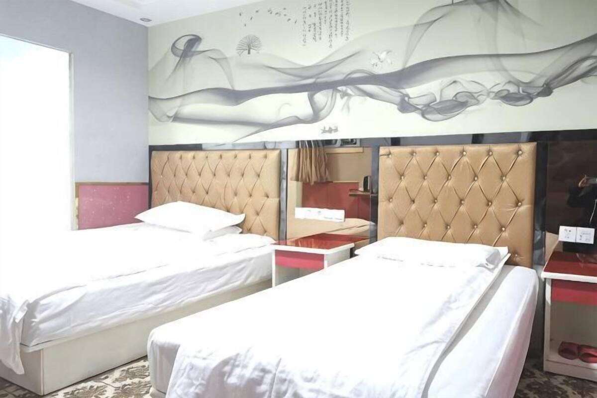 Une chambre d’hôtel avec deux lits, un miroir et un mur décoratif.