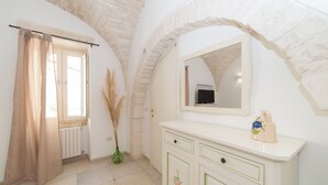 Une salle de bain avec un meuble-lavabo blanc, un miroir et un radiateur.