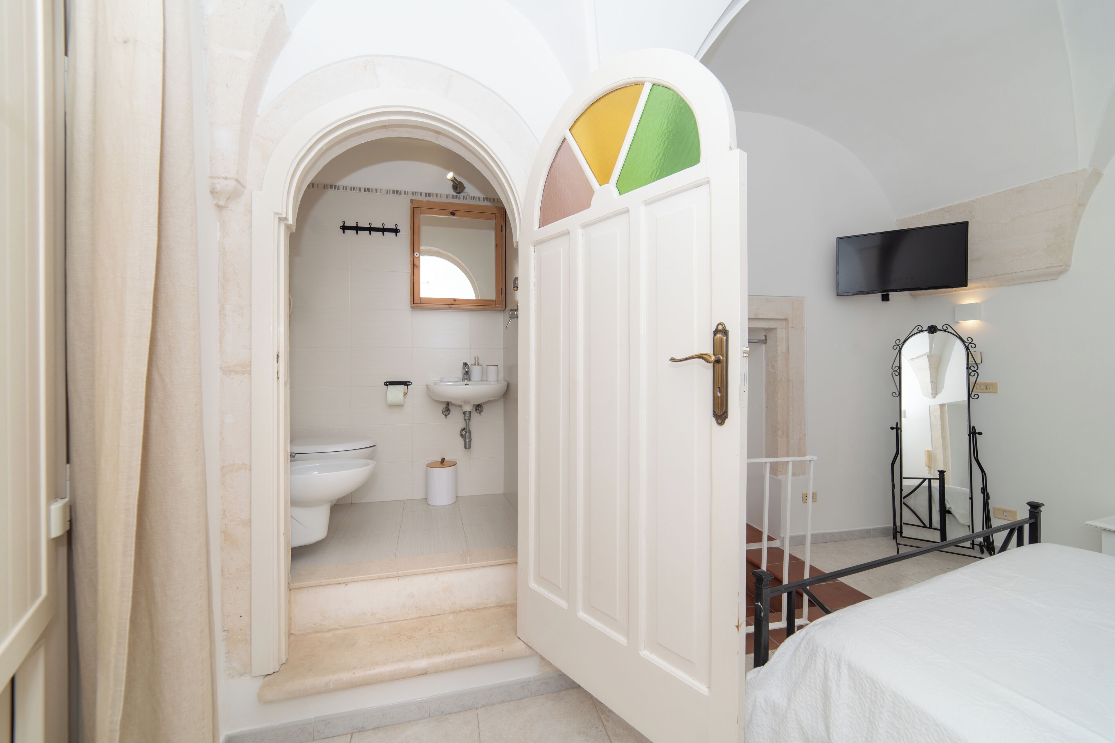 Een badkamer met toilet, wastafel en spiegel.