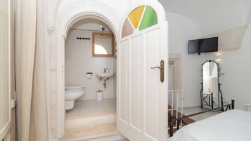 Een badkamer met toilet, wastafel en spiegel.