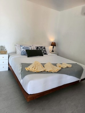 A neatly made bed with a grey throw blanket and rolled towels. - Villa Sereno Beachfront Koh Samui (Koh Samui)