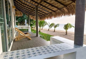 A beachside balcony with a thatched roof, a white outdoor seating area, and a view of the ocean. - Villa Sereno Beachfront Koh Samui (Koh Samui)