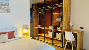 A bedroom with a bed, a desk, a chair, a wardrobe, and a bedside lamp. - Villa Sereno Beachfront Koh Samui (Koh Samui)