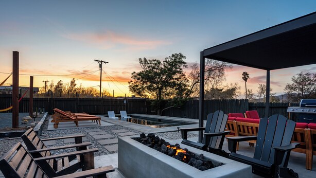 An outdoor patio area with seating, a fire pit, and a barbecue grill. - Pool, Hot Tub Heating, BBQ, AC & Private Yard, Pet Friendly, 10mins to JTNP! (Joshua Tree)