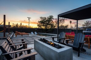 An outdoor patio area with seating, a fire pit, and a barbecue grill. - Pool, Hot Tub Heating, BBQ, AC & Private Yard, Pet Friendly, 10mins to JTNP! (Joshua Tree)