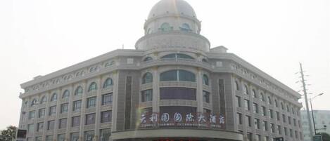 A large, historic building with a central dome and multiple windows.