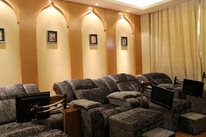 A cinema room with multiple rows of seating, a screen, and a sound system.