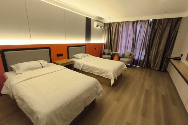 A hotel room with two beds, a nightstand, a chair, and a large window with curtains. - Erenhot Jingtai Hotel (Erenhot)