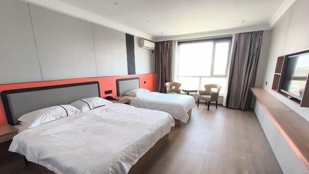 A hotel room with two beds, a TV, a desk, and a chair. - Erenhot Jingtai Hotel (Erenhot)