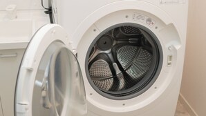 Eine weiße Waschmaschine mit Bedienfeld und Tür, frontal abgebildet.