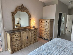 Cozy retreat with a large bed, dresser, and mirror.