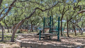 A park with a playground, benches, and trees. - Relax in This Spacious 4BR San Antonio Home with WiFi and AC (San Antonio)