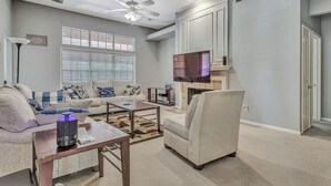 A living room with a sofa, armchairs, a coffee table, a fireplace, and a ceiling fan. - Relax in This Spacious 4BR San Antonio Home with WiFi and AC (San Antonio)