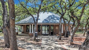 A building with a brick facade, large windows, and a covered entrance area. - Relax in This Spacious 4BR San Antonio Home with WiFi and AC (San Antonio)