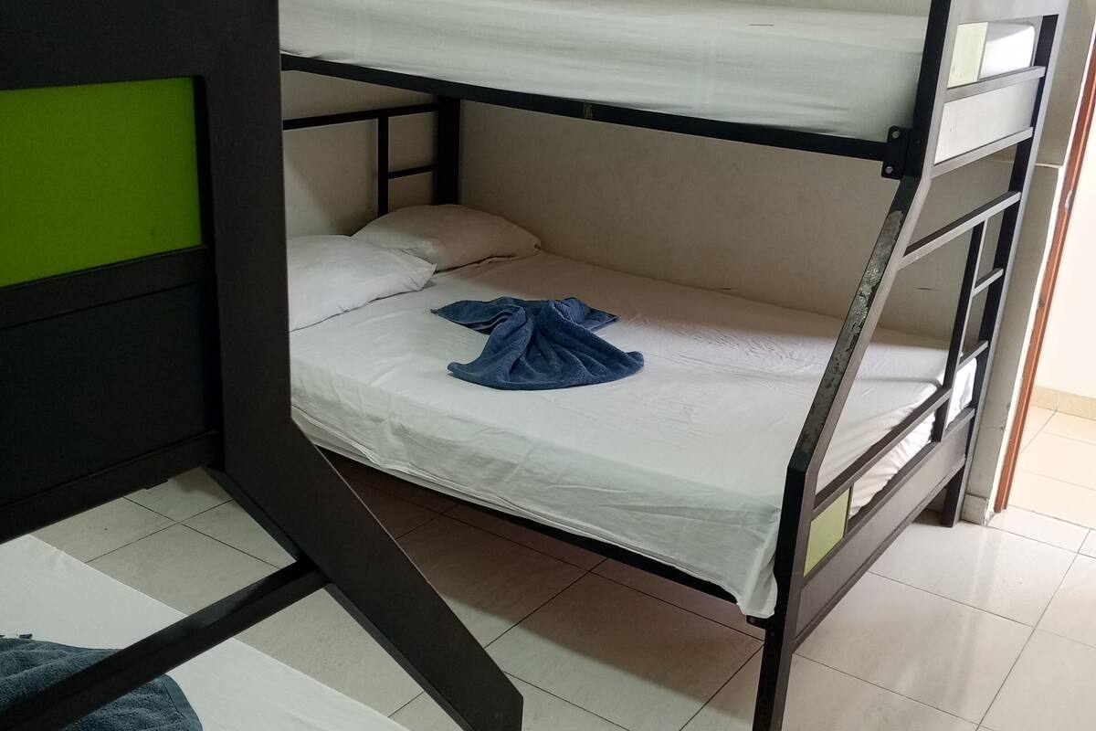 A bunk bed with a green headboard and a white mattress.