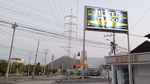 Señal de hotel con el nombre 'HOTEL PRADO' y un número de contacto.