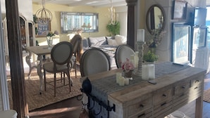 A spacious dining area with a high ceiling, chandeliers, and a view of the outdoors. - Oceanfront, beach access Cozy bed & breakfast loaded  amenities , Sunny Saltair (Ladysmith)