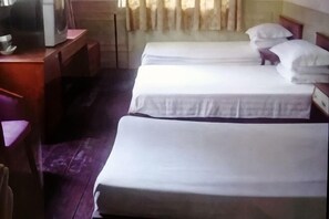 A room with two beds, a desk, and a chair.