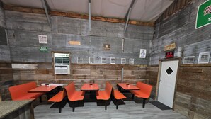 A restaurant with wooden walls, multiple tables and orange chairs, and signs indicating a heavy drinker area and no smoking. - Great place for allot of fun events & all your people under 1 roof low cost! (Hunnewell)