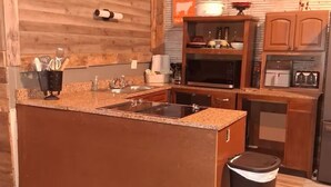 A modern kitchen with wooden cabinetry, a granite countertop, and stainless steel appliances. - Great place for allot of fun events & all your people under 1 roof low cost! (Hunnewell)